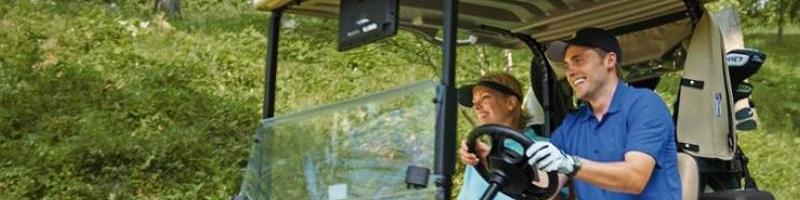 Two people smiling in a golf cart