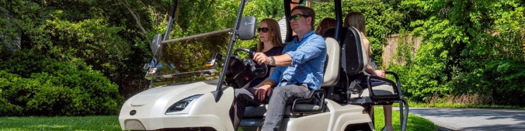 Group riding in a golf cart outdoors